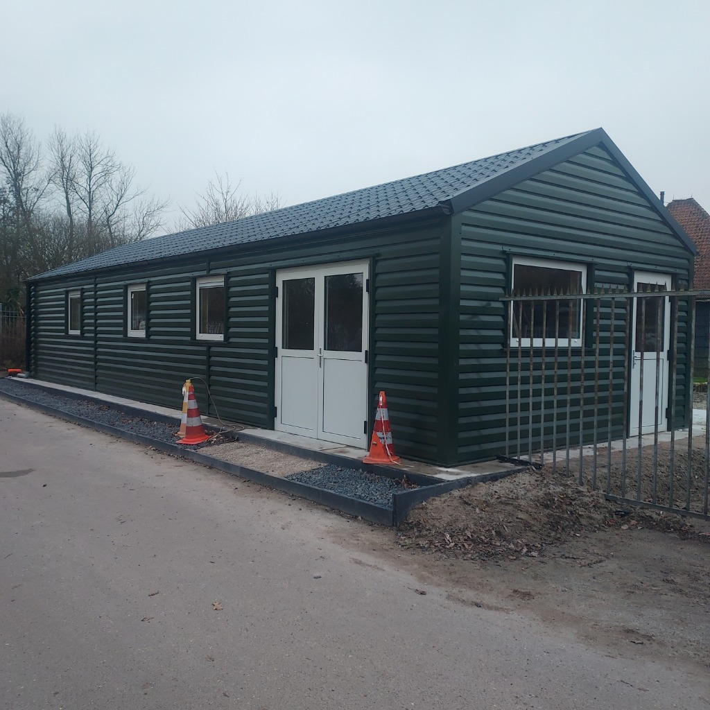 Geïsoleerde dichte loods met dubbele deuren en donkergroene profielplaat